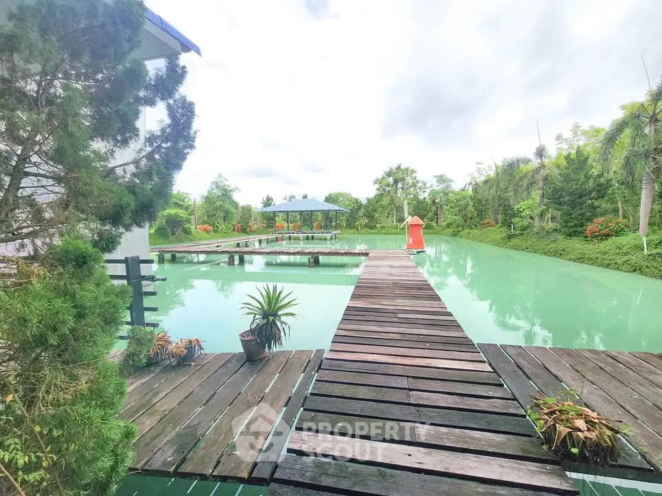 Stunning waterfront property with wooden dock and lush greenery, perfect for serene living.