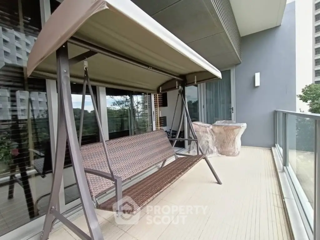 Spacious balcony with swing chair and modern design, perfect for relaxation and outdoor enjoyment.