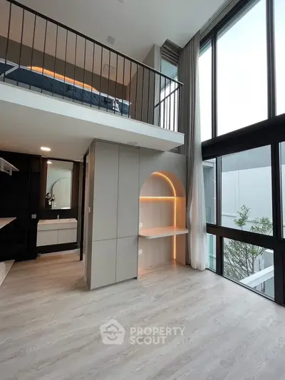 Modern loft apartment with high ceilings and large windows, featuring a stylish mezzanine and sleek interior design.