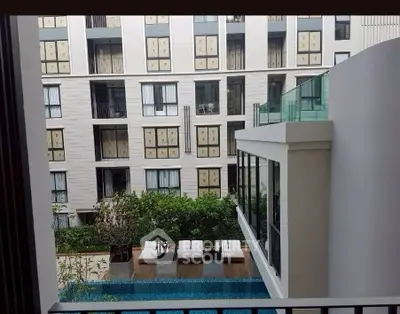 Modern apartment building with pool view and lush greenery