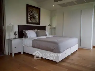 Spacious modern bedroom with elegant decor and hardwood flooring