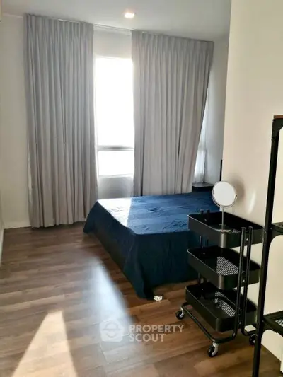 Spacious bedroom with elegant curtains and wooden flooring