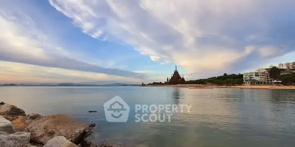 Stunning beachfront view with unique architectural landmark and serene waters.