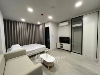 Modern studio apartment with cozy living area and sleek furnishings, perfect for urban living.