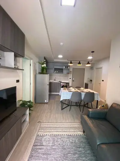 Modern open-plan living room and kitchen with stylish decor and dining area.