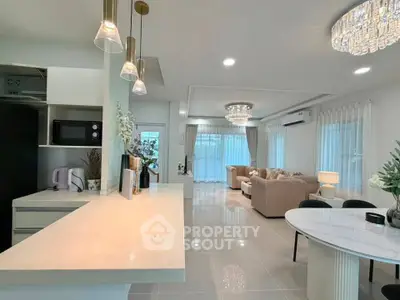 Luxurious open-plan living room and kitchen with elegant lighting and modern decor.