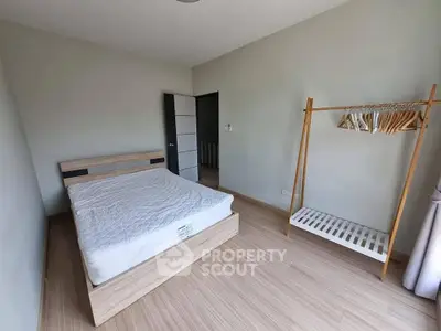 Spacious bedroom with minimalist design and wooden flooring