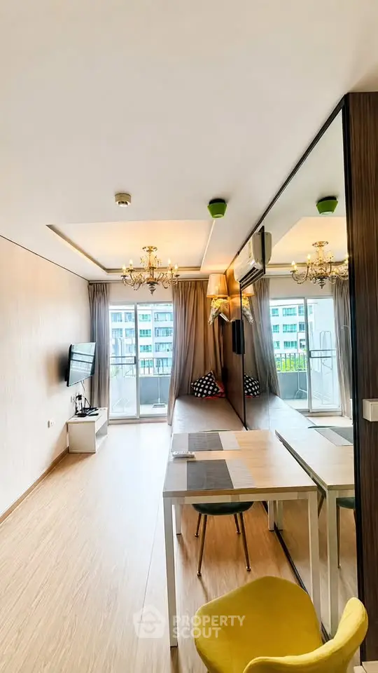 Modern living room with mirrored wall and balcony view in a stylish apartment.