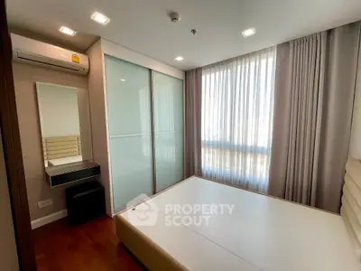 Modern bedroom with large window and sleek storage solutions