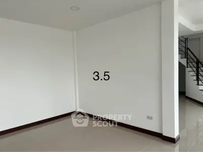 Spacious empty room with staircase, perfect for customization and modern living.