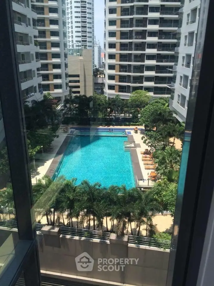 Luxurious high-rise apartment complex with stunning pool view and lush greenery.