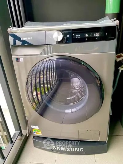 Modern Samsung washing machine on a balcony with city view, perfect for urban living convenience.