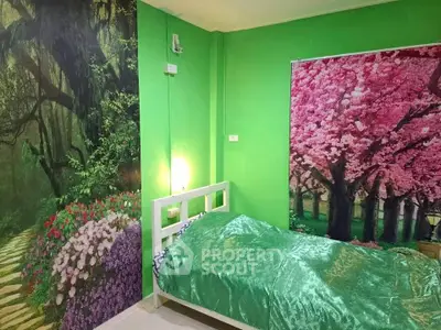 Vibrant bedroom with nature-themed wall murals and green bedding, creating a serene and unique atmosphere.