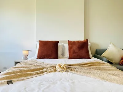 Cozy bedroom with stylish decor and plush pillows, perfect for relaxation.