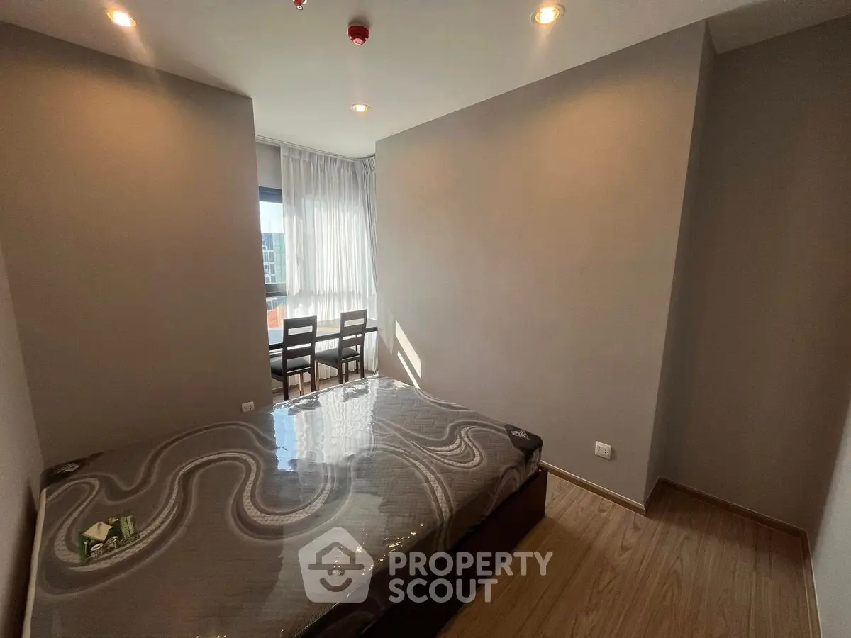 Cozy bedroom with natural light and modern furnishings in a stylish apartment.