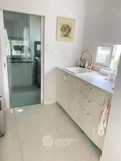 Modern kitchen with sleek cabinetry and elegant faucet, featuring a bright and airy design.