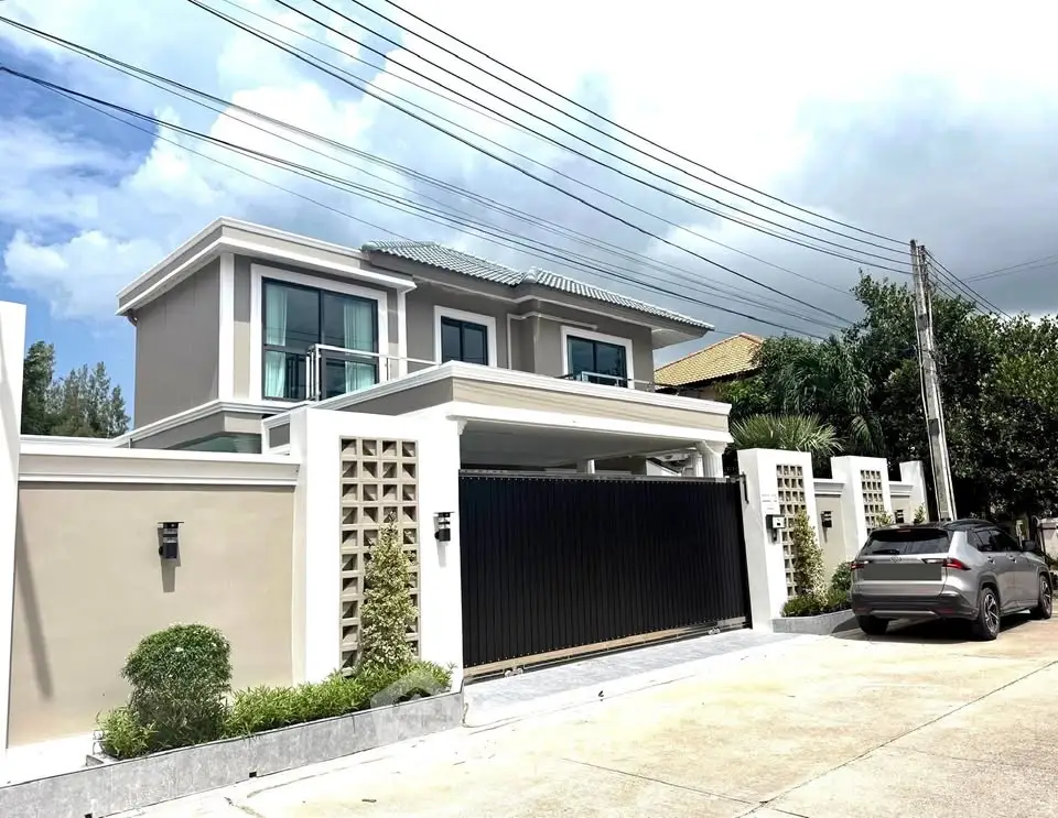 Stunning modern two-story house with sleek design and gated entrance in a serene neighborhood.