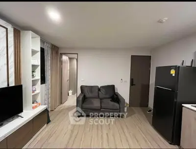 Modern living room with sleek furniture and open layout, featuring a cozy sofa and stylish shelving.