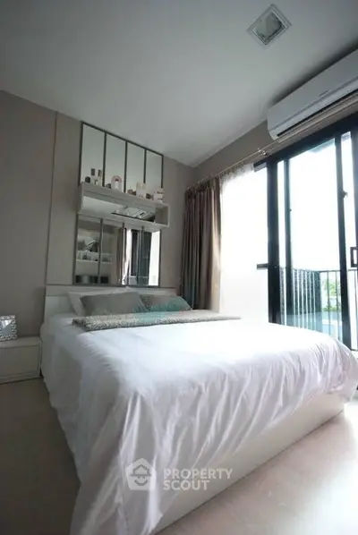 Modern bedroom with large window and stylish decor in a contemporary apartment.