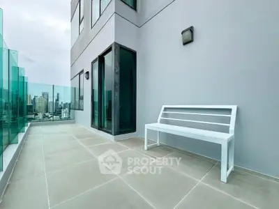 Spacious balcony with modern glass railing and city skyline view