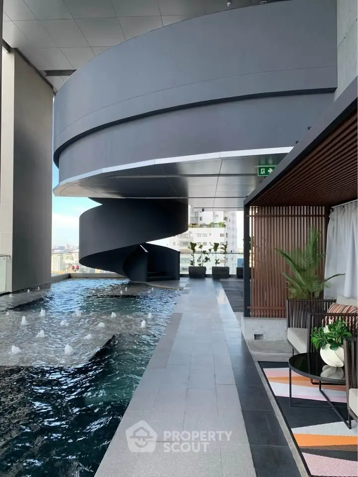 Luxurious rooftop pool with modern spiral staircase and stylish seating area.