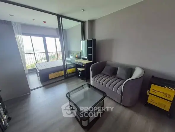 Modern apartment with cozy living room and bedroom, featuring stylish furniture and large windows.
