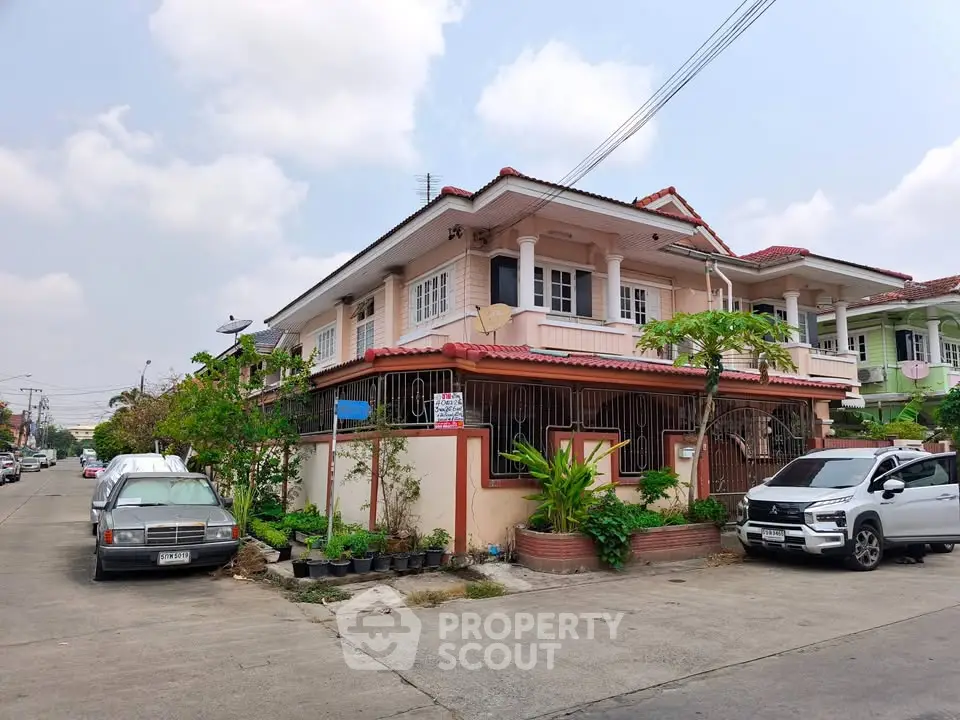 Charming two-story house with balcony and lush garden in a suburban neighborhood, perfect for family living.