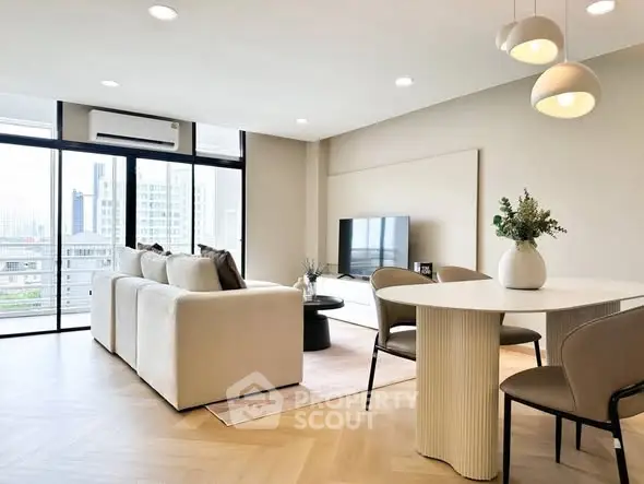 Modern living room with elegant decor and city view, featuring cozy seating and stylish dining area.
