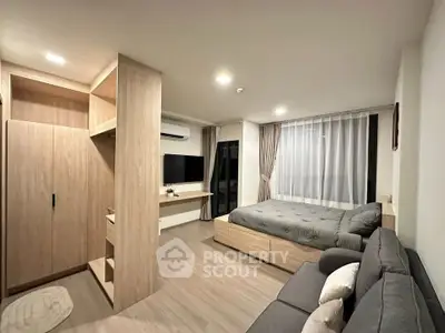 Modern studio apartment with cozy living area and stylish wooden furnishings.