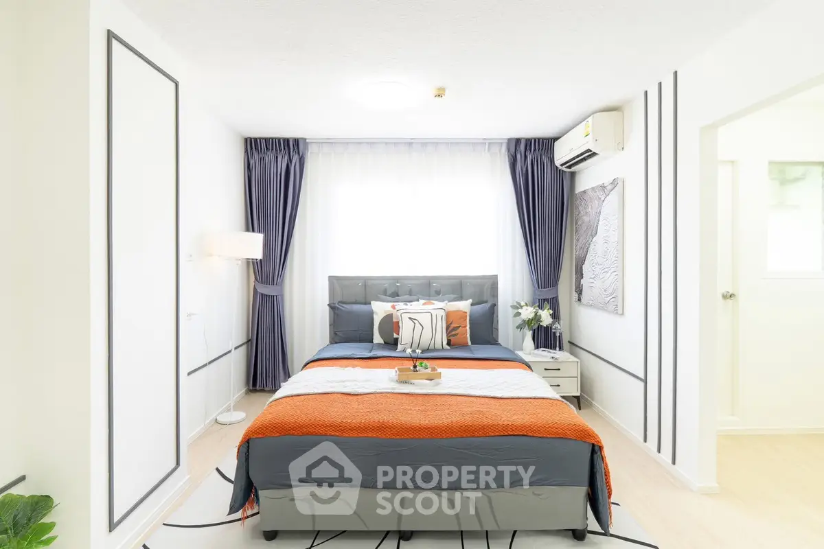 Modern bedroom with stylish decor, featuring a cozy bed, elegant curtains, and air conditioning for comfort.