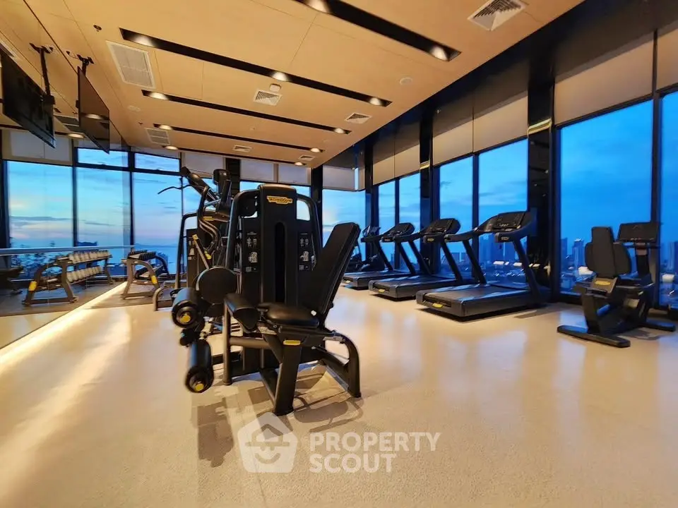 Luxurious high-rise gym with panoramic city views and modern fitness equipment.
