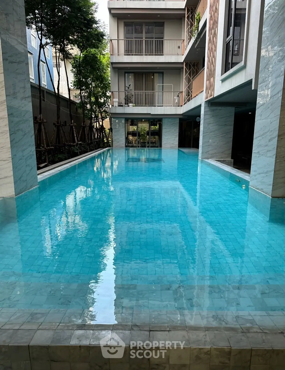 Luxurious residential building with a stunning swimming pool and modern architecture.