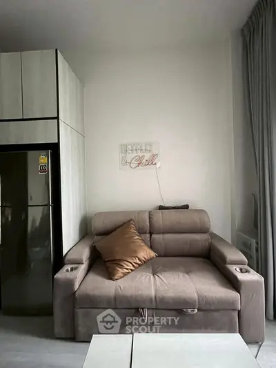 Modern living room with cozy sofa and sleek fridge