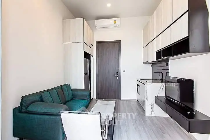 Modern living room with sleek kitchen, featuring stylish furniture and contemporary design.