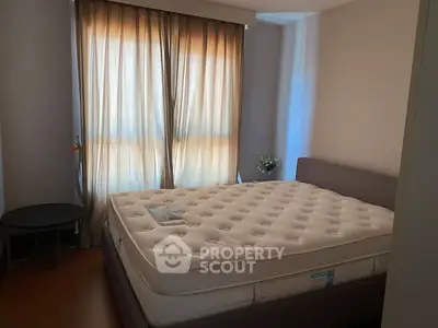 Cozy bedroom with large window and comfortable mattress, perfect for relaxation.