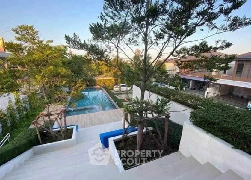 Luxurious residential pool area with lush greenery and modern design.