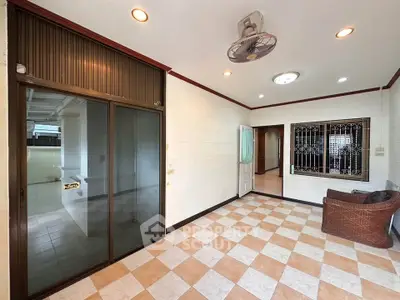 Spacious living room with tiled flooring and ceiling fan in a modern home.