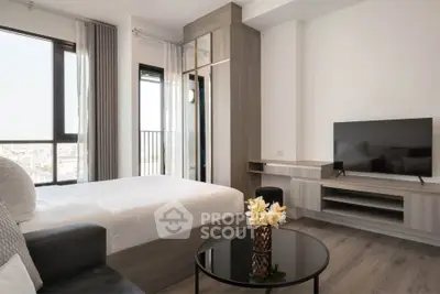 Modern bedroom with city view, sleek furniture, and flat-screen TV
