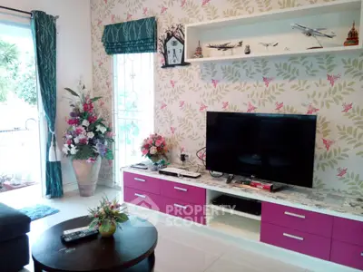 Charming living room with modern decor, floral wallpaper, and sleek entertainment center.