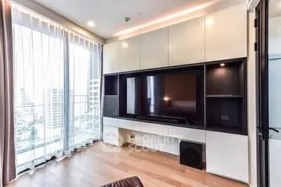Modern living room with large TV and floor-to-ceiling windows offering city views.