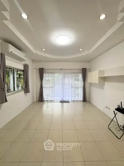 Spacious living room with modern ceiling lights and large windows for natural light.
