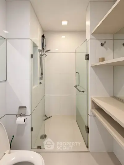 Modern bathroom with glass shower enclosure and sleek shelving