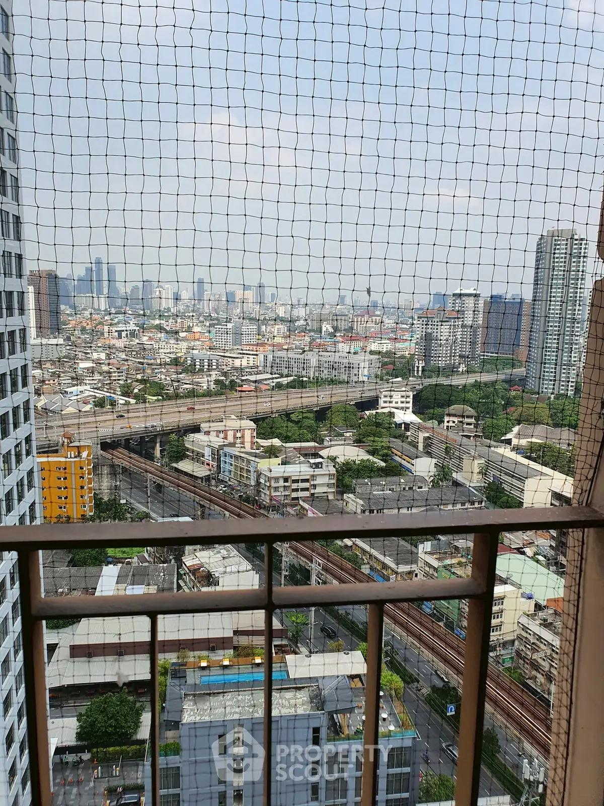 Stunning high-rise balcony view of cityscape with expansive skyline and urban landscape.