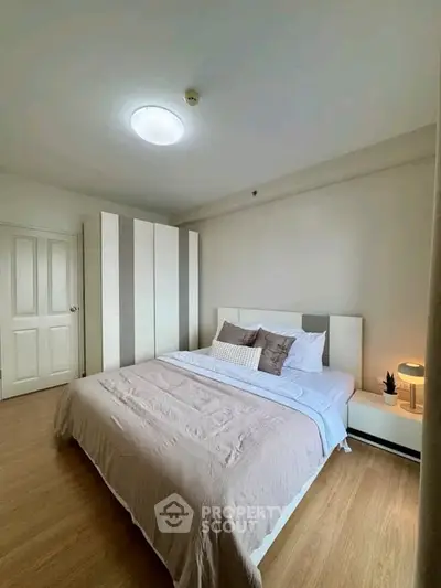 Spacious bedroom with modern decor and ample natural light