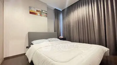 Modern bedroom with cozy bed and elegant curtains in a stylish apartment.