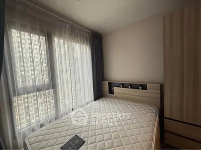 Modern bedroom with large window and stylish wardrobe in urban apartment.