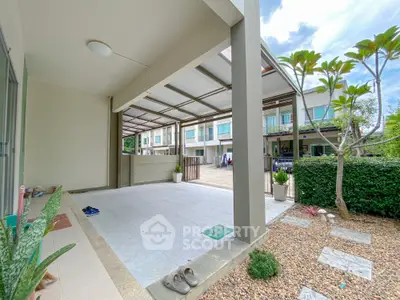 Spacious modern townhouse entrance with covered parking and landscaped garden