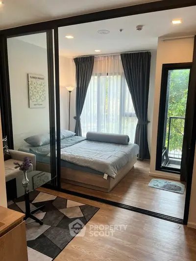 Modern bedroom with glass partition and balcony view, featuring elegant decor and natural light.