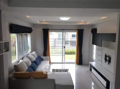 Modern living room with large windows and stylish furniture, perfect for relaxation and entertainment.