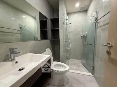 Modern bathroom with glass shower and sleek fixtures in a contemporary apartment.
